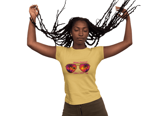 Person wearing a colorful Miami Carnival 2025 t-shirt featuring vibrant tropical artwork, flags, sunglasses, and festive Caribbean-inspired graphics.