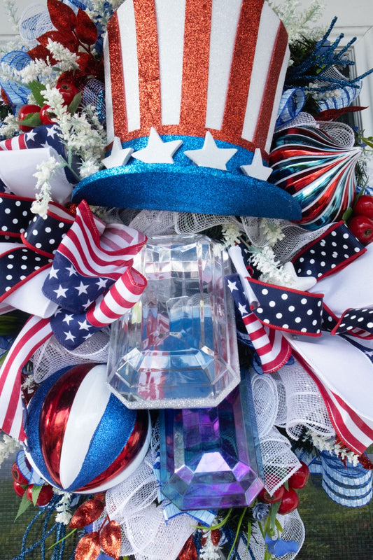 Patriotic Uncle Sam wreath with red white and blue ribbons glitter top hat stars and mesh perfect for 4th of July front door decor