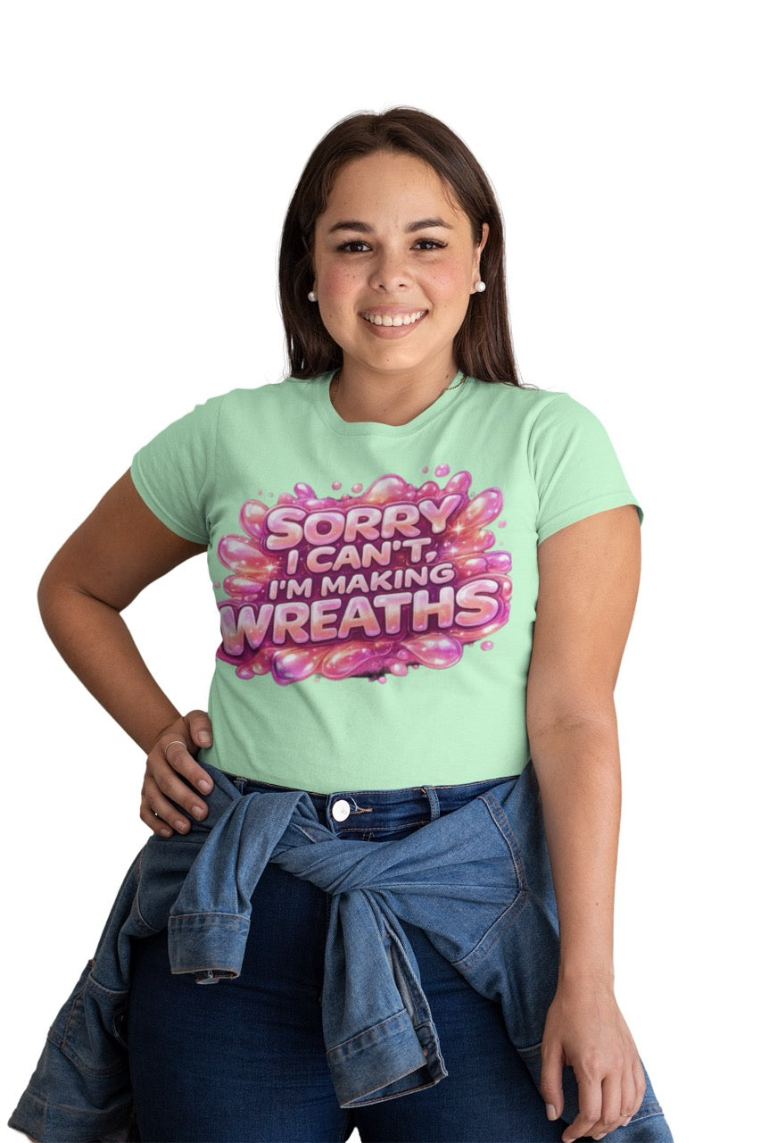 Graphic t-shirt featuring the phrase “Sorry I Can’t, I’m Making Wreaths” in bold bubble-style lettering, designed for wreath makers, crafters, and DIY enthusiasts.