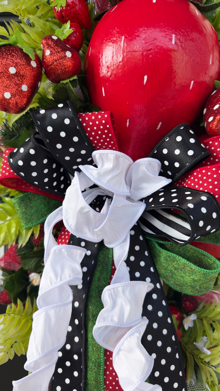 Luxury handmade strawberry door swag with oversized red strawberries, glitter strawberry ornaments, bright green foliage, white flowers, and a designer black, red, white, and green ribbon bow, perfect for summer front door décor and farmhouse-style decorating. 🍓✨
