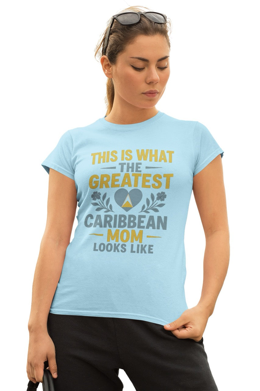 Woman wearing a blue T-shirt with text reading “This is what the greatest Caribbean mom looks like,” featuring a heart with island-inspired colors and floral accents.