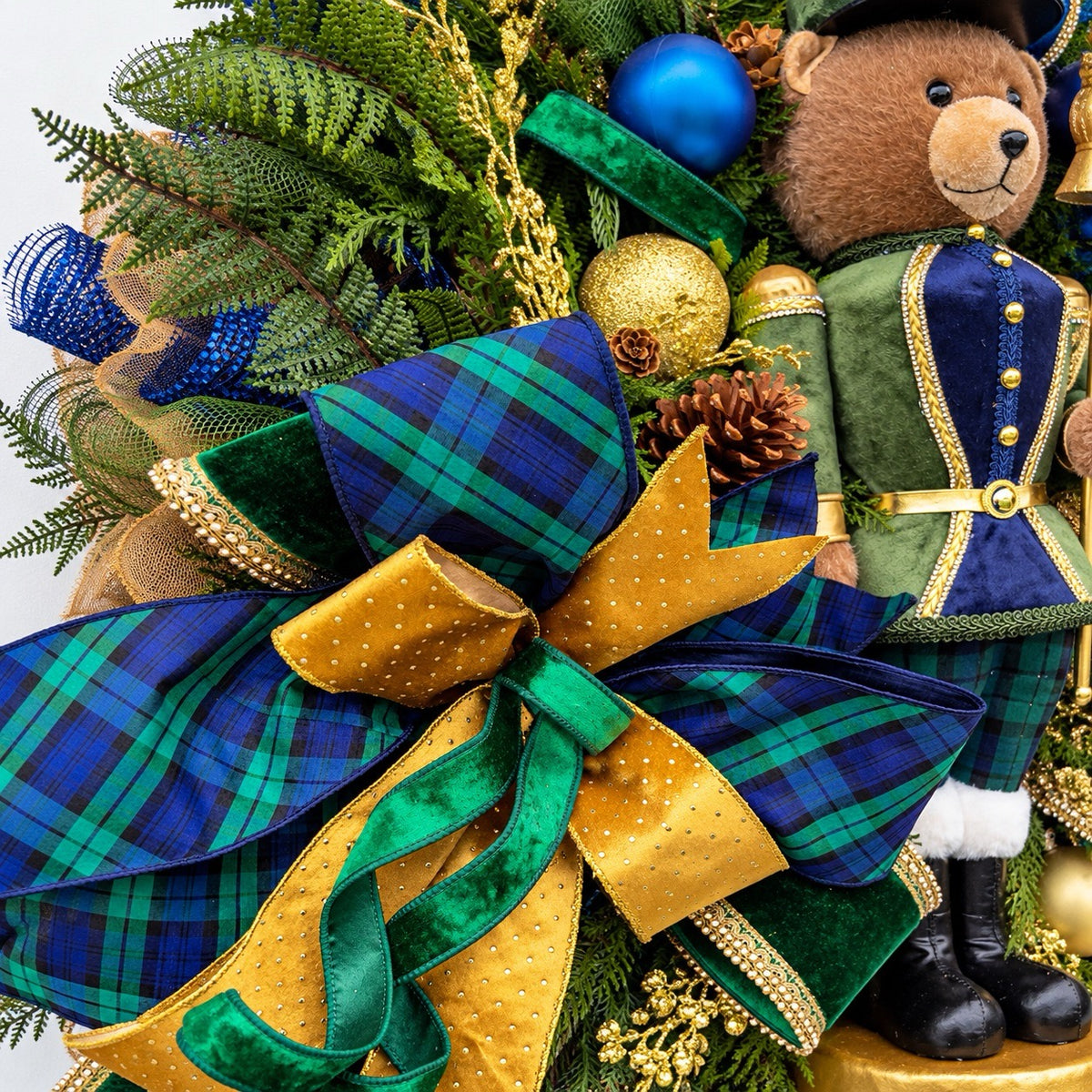 Detail of navy and gold ornaments, frosted pinecones and gold berries.