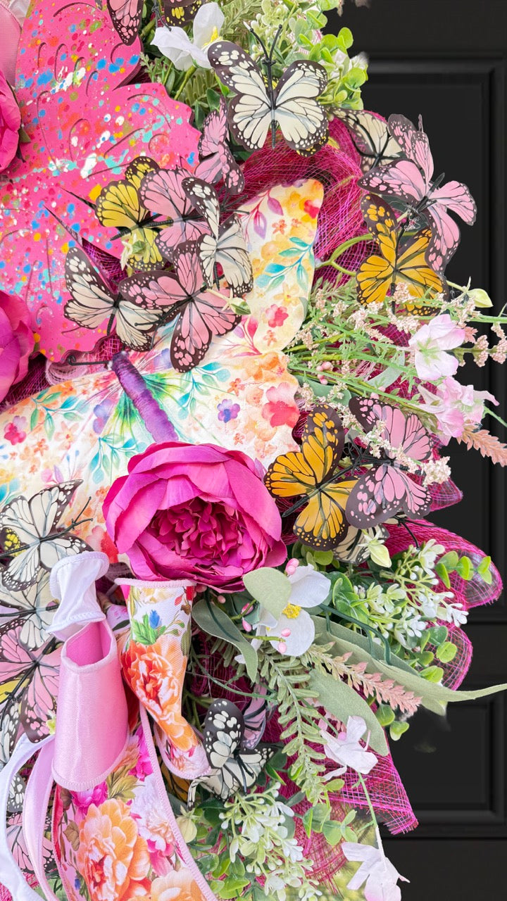 Handmade pink butterfly wreath featuring vibrant florals, layered designer ribbons, lush greenery, and colorful butterflies. This whimsical spring and summer front door wreath creates a beautiful statement piece perfect for entryways, porch decor, and everyday home decorating.