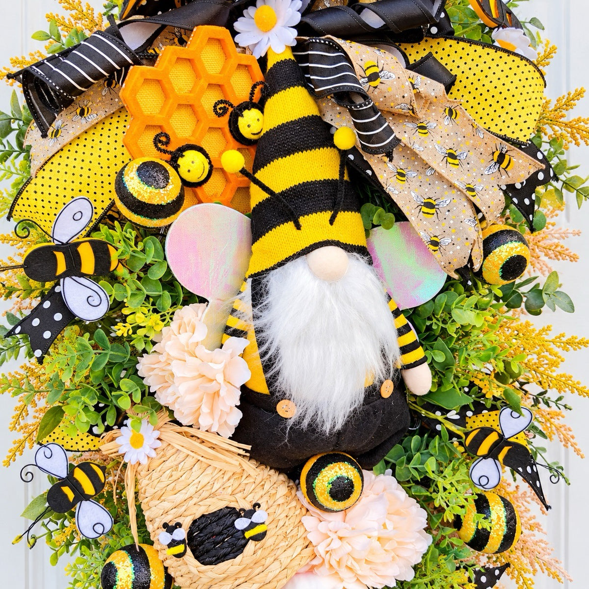 Handmade Queen Bee Manor wreath featuring a bee gnome, woven beehive, yellow and black designer bow, honeycomb accents, florals, bees, and lush greenery.