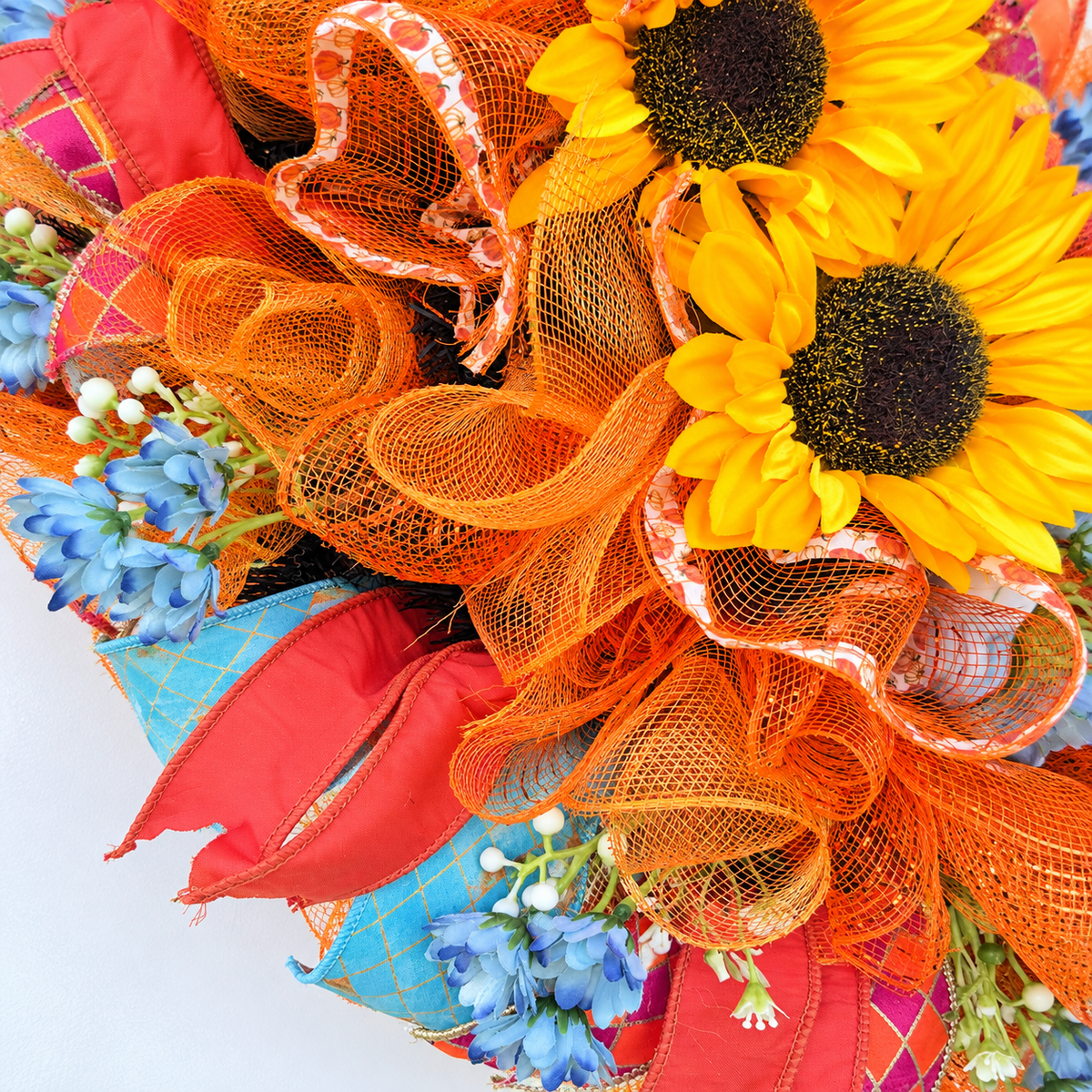 Handmade fall rooster wreath featuring vibrant yellow sunflowers, dusty blue flowers, orange deco mesh, coral and turquoise ribbons, and a colorful rooster centerpiece. A full farmhouse-style autumn wreath displayed on a white front door.