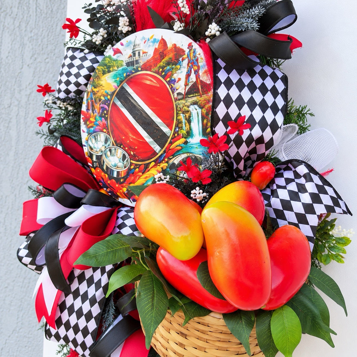 Close-up of woven basket filled with artificial red orange and yellow peppers surrounded by green leaves on a Trinidad and Tobago Caribbean wreath.