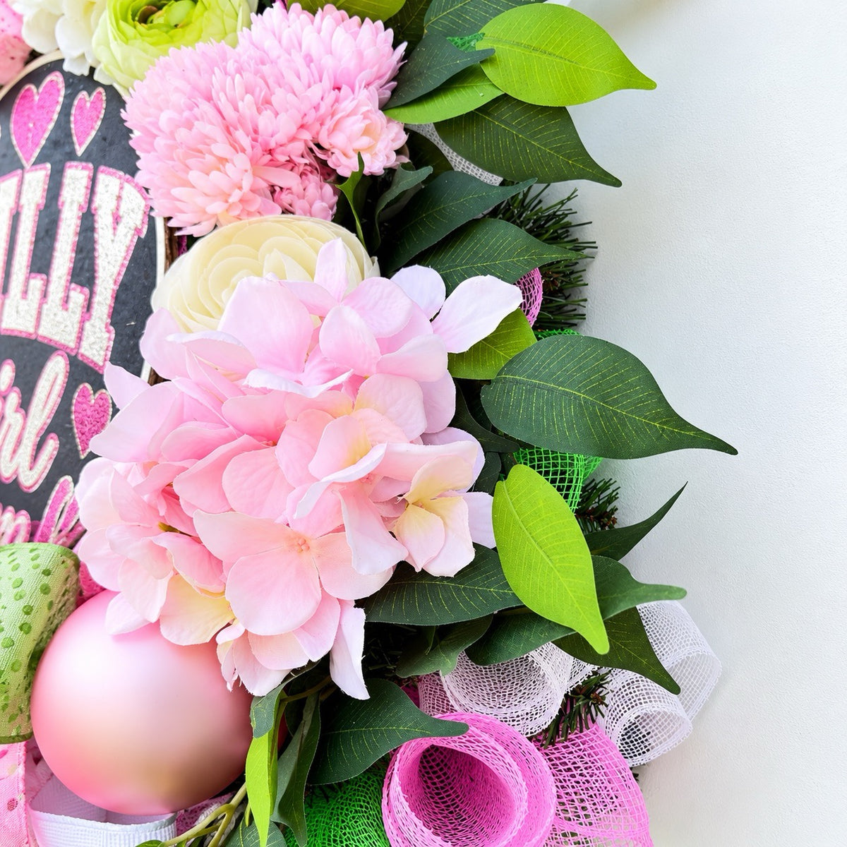 Detailed view of pink hydrangeas, ivory peonies, green floral accents, and lush artificial greenery on Philadelphia-inspired wreath.