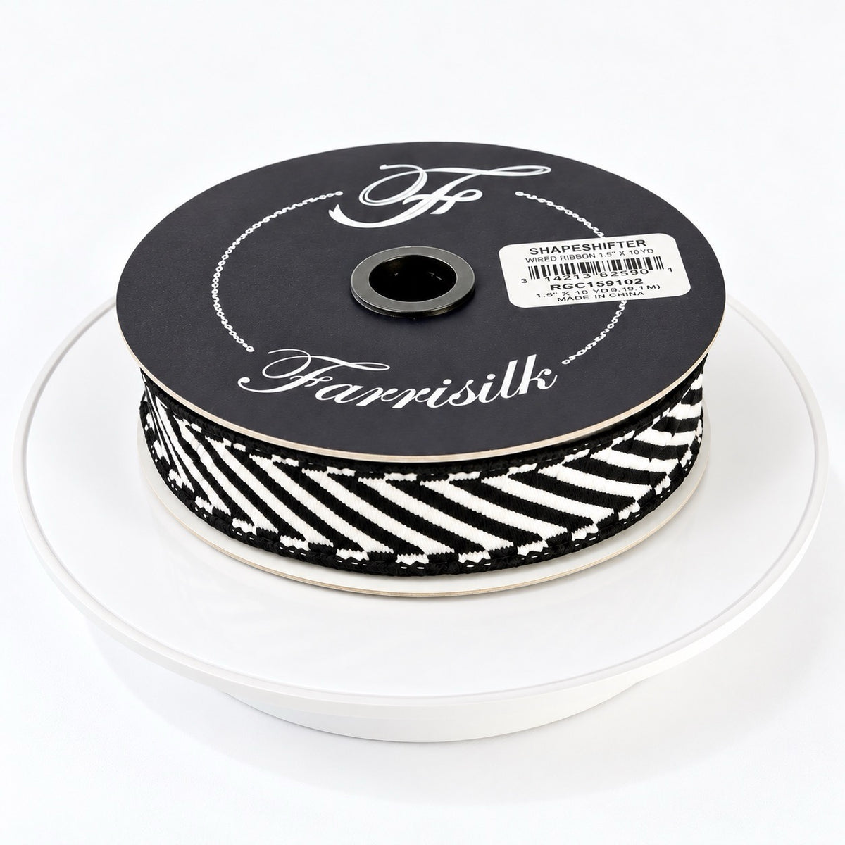 Farrisilk Shapeshifter black and white geometric wired ribbon, 1 inches wide, displayed on a full 10-yard spool with decorative ribbon loops.