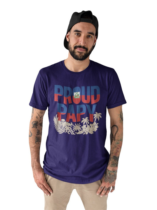 Man wearing a purple T-shirt with bold text reading “Proud Papy,” featuring Haitian flag colors and tropical floral accents.