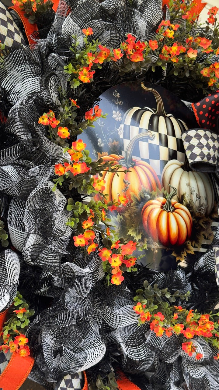 Harlequin Harvest Manor Wreath featuring lavender deco mesh, black florals, vibrant harlequin ribbon, sunflowers, and a whimsical purple pumpkin centerpiece displayed on a black front door.