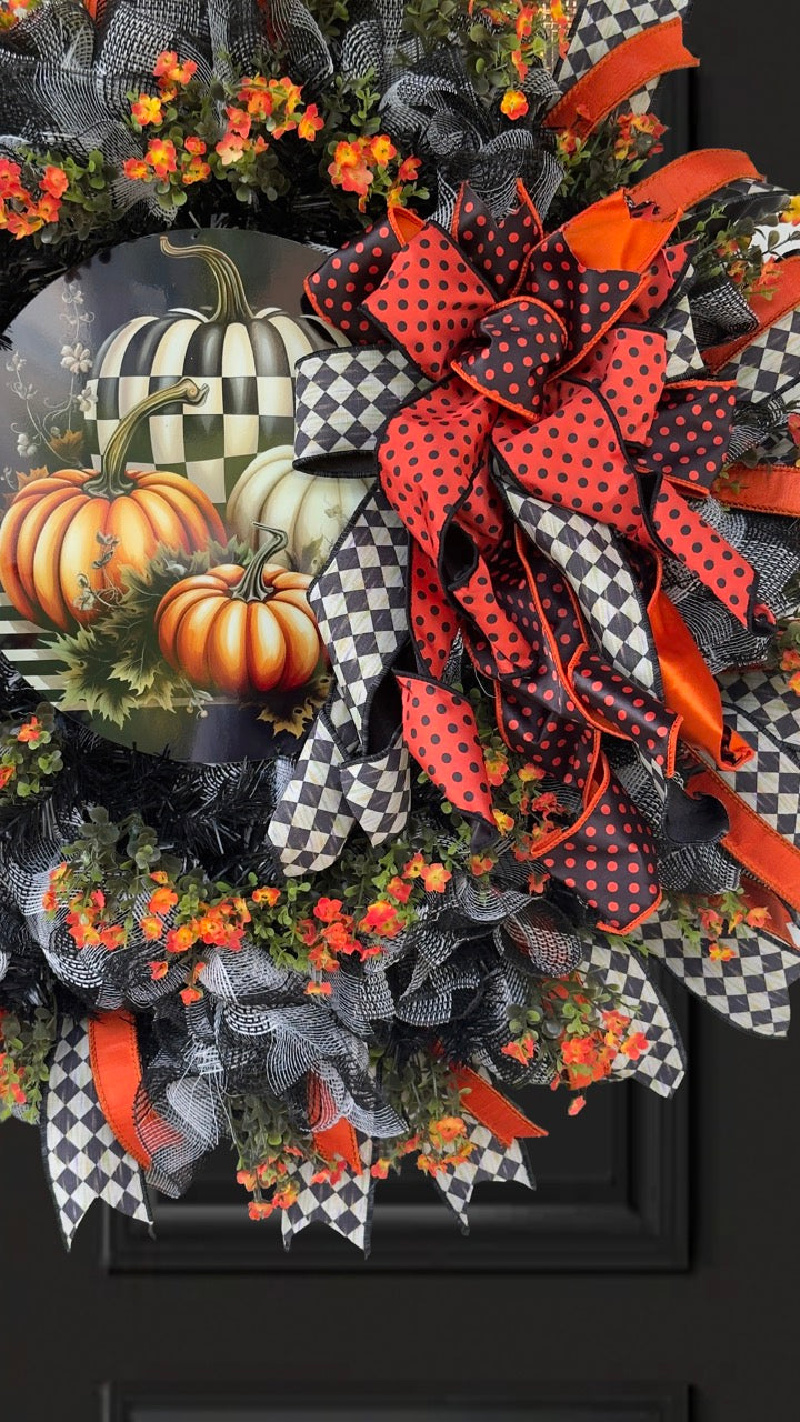Harlequin Harvest Manor Wreath featuring lavender deco mesh, black florals, vibrant harlequin ribbon, sunflowers, and a whimsical purple pumpkin centerpiece displayed on a black front door.