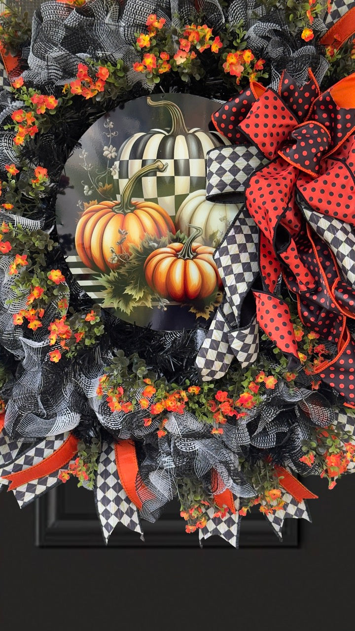 Harlequin Harvest Manor Wreath featuring lavender deco mesh, black florals, vibrant harlequin ribbon, sunflowers, and a whimsical purple pumpkin centerpiece displayed on a black front door.