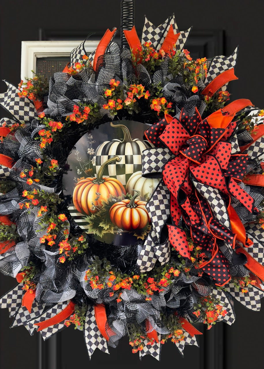 Harlequin Harvest Manor Wreath featuring lavender deco mesh, black florals, vibrant harlequin ribbon, sunflowers, and a whimsical purple pumpkin centerpiece displayed on a black front door.