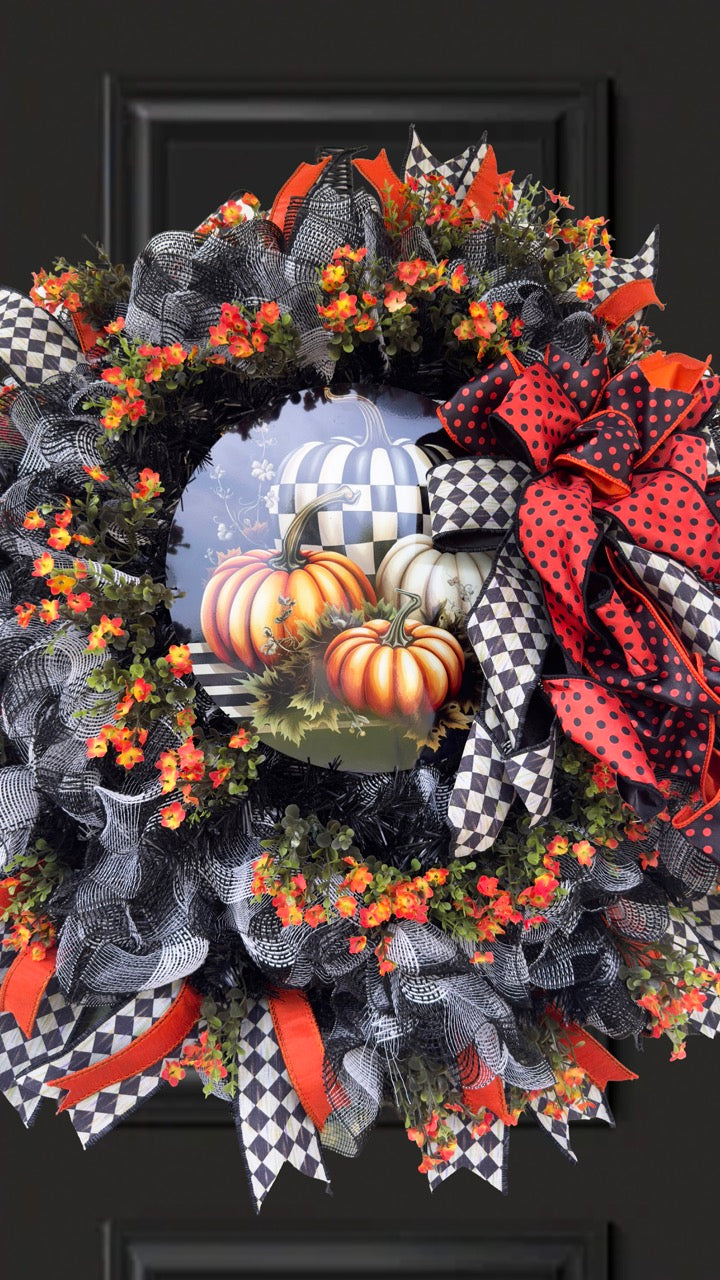 Harlequin Harvest Manor Wreath featuring lavender deco mesh, black florals, vibrant harlequin ribbon, sunflowers, and a whimsical purple pumpkin centerpiece displayed on a black front door.