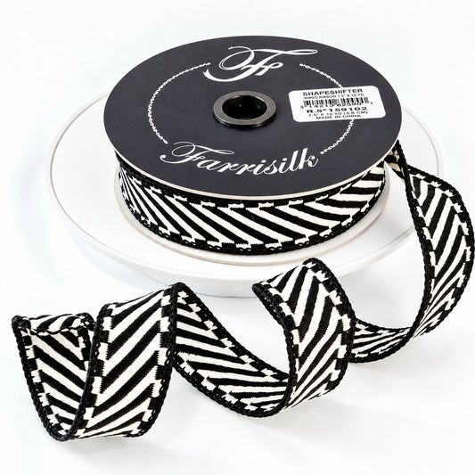 Farrisilk Shapeshifter black and white geometric wired ribbon, 1 inches wide, displayed on a full 10-yard spool with decorative ribbon loops.