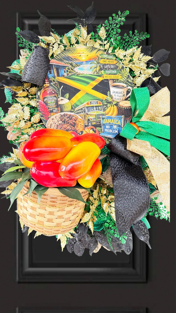 Luxury handmade Jamaica-inspired door wreath featuring green, black, and gold designer ribbons, tropical fruit basket, glittered foliage, and colorful island-themed artwork celebrating Jamaican culture and Caribbean décor.
