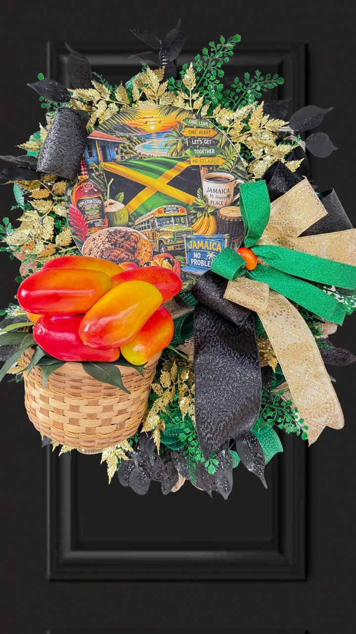 Luxury handmade Jamaica-inspired door wreath featuring green, black, and gold designer ribbons, tropical fruit basket, glittered foliage, and colorful island-themed artwork celebrating Jamaican culture and Caribbean décor.
