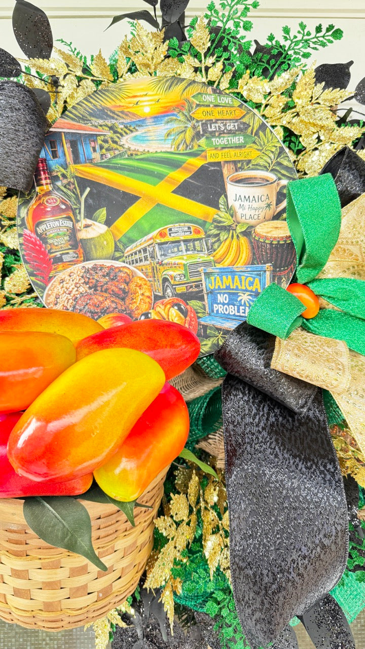 Luxury handmade Jamaica-inspired door wreath featuring green, black, and gold designer ribbons, tropical fruit basket, glittered foliage, and colorful island-themed artwork celebrating Jamaican culture and Caribbean décor.