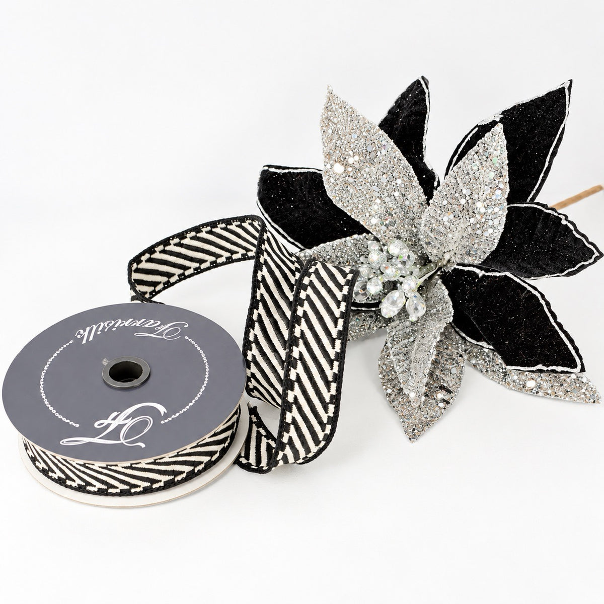Farrisilk Shapeshifter black and white geometric wired ribbon, 1 inches wide, displayed on a full 10-yard spool with decorative ribbon loops.