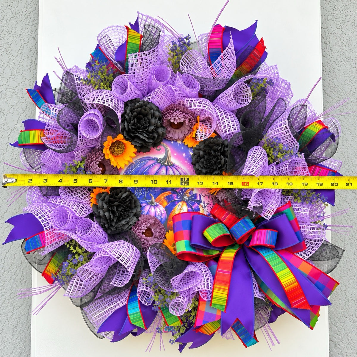 1. Velvet Eclipse Halloween wreath shown with measuring tape for finished width reference