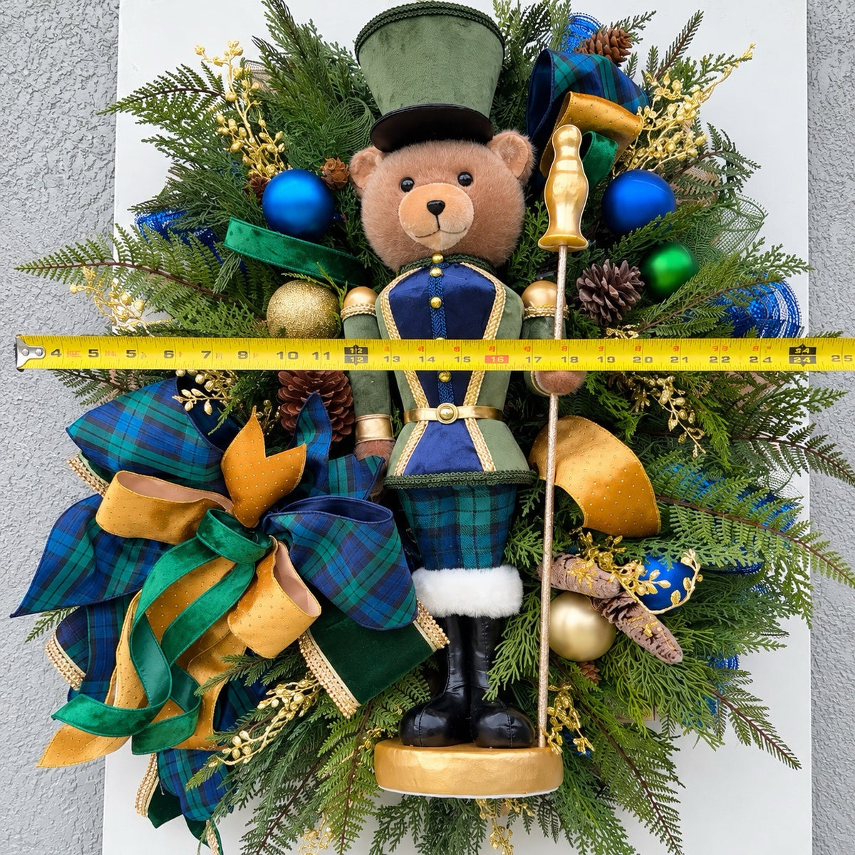 Detail of navy and gold ornaments, frosted pinecones and gold berries.