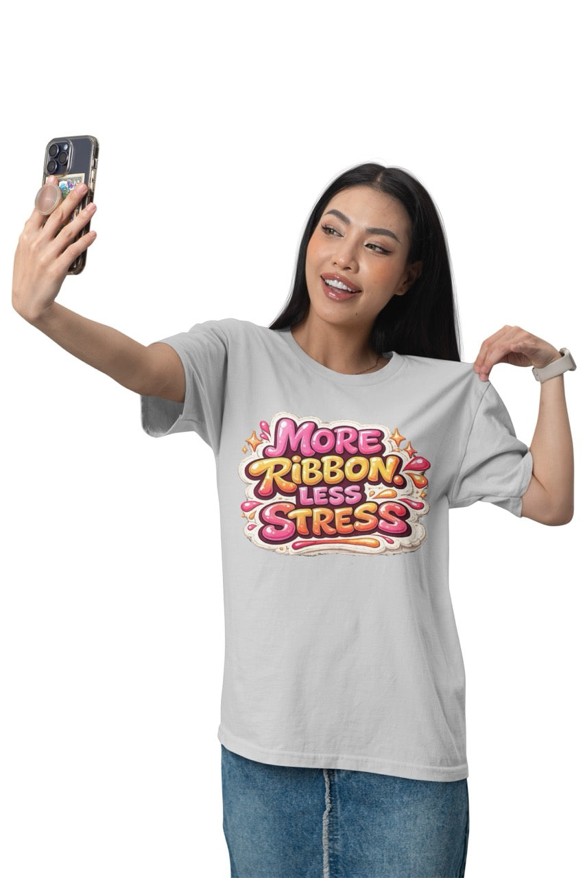 Unisex t-shirt featuring the phrase “More Ribbon. Less Stress.” in bold decorative lettering with playful craft-inspired accents, designed for wreath makers, crafters, and DIY enthusiasts.