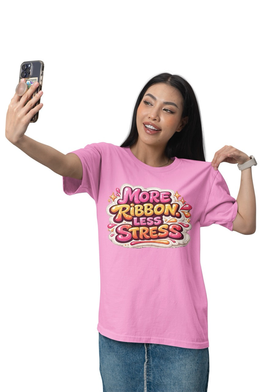 Unisex t-shirt featuring the phrase “More Ribbon. Less Stress.” in bold decorative lettering with playful craft-inspired accents, designed for wreath makers, crafters, and DIY enthusiasts.