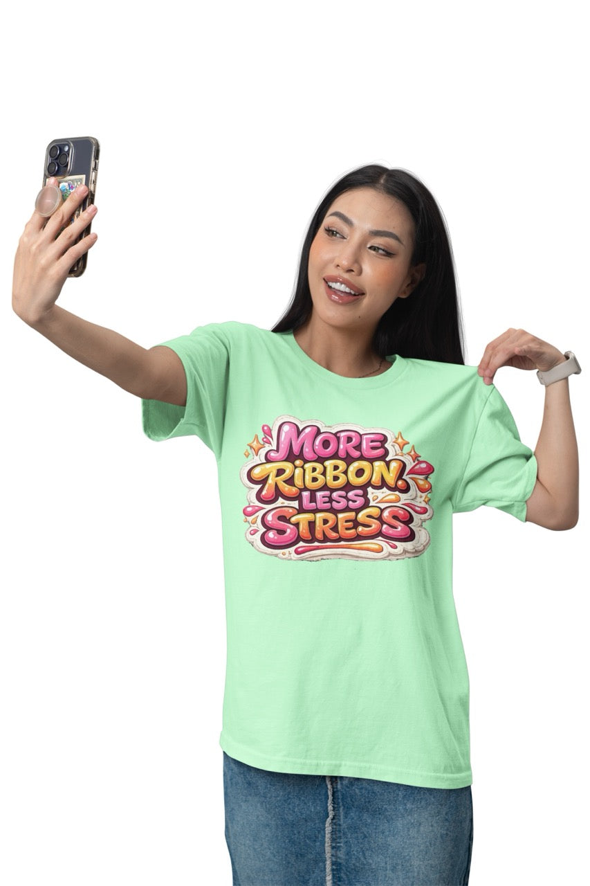 Unisex t-shirt featuring the phrase “More Ribbon. Less Stress.” in bold decorative lettering with playful craft-inspired accents, designed for wreath makers, crafters, and DIY enthusiasts.