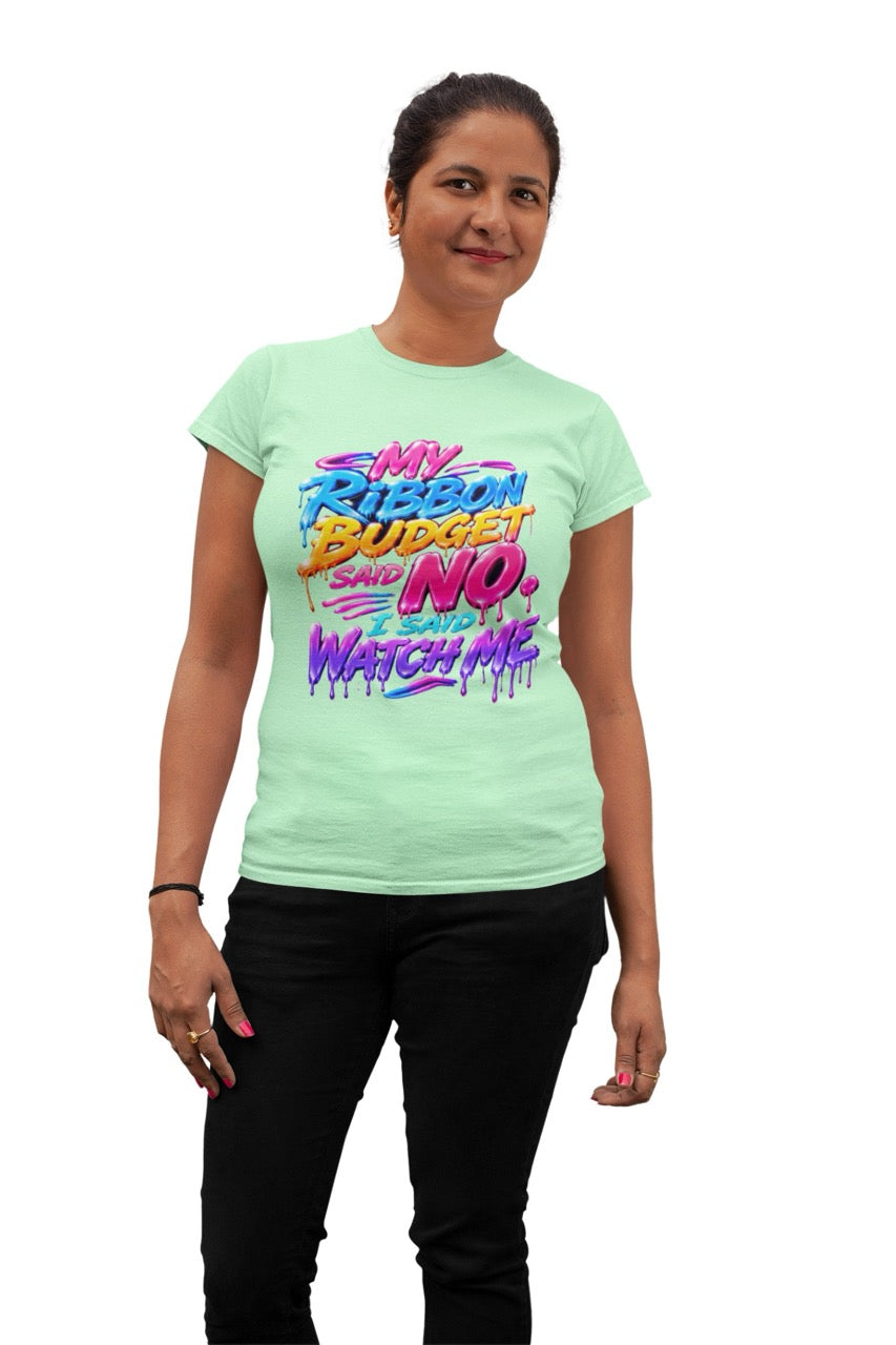 Graphic t-shirt featuring the phrase “My Ribbon Budget Said No, I Said Watch Me” in bold colorful lettering with a dripping paint effect, designed for wreath makers, crafters, and ribbon enthusiasts.
