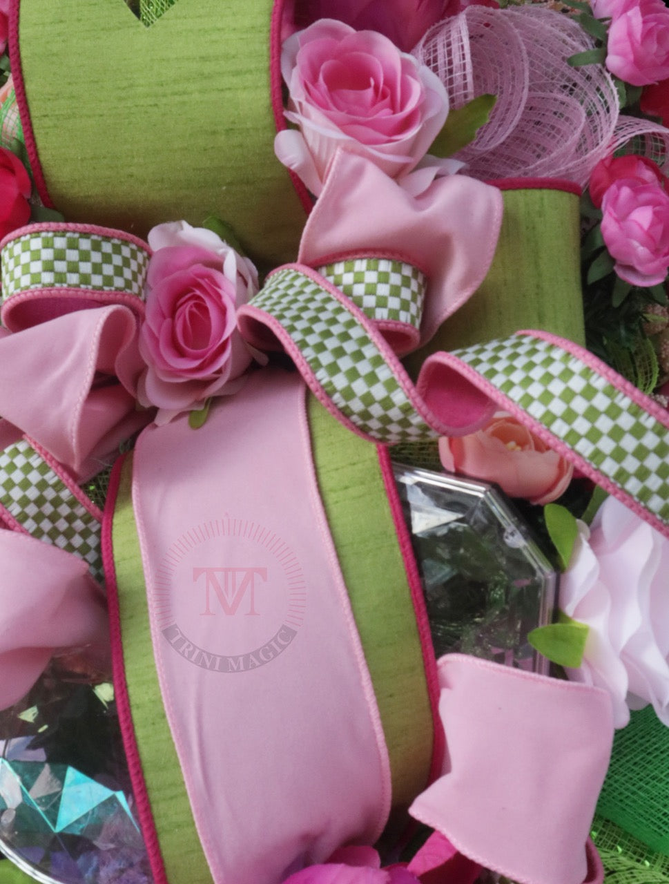 Pink floral gift box swag wreath with peonies, roses, green ribbon, and elegant front door decor