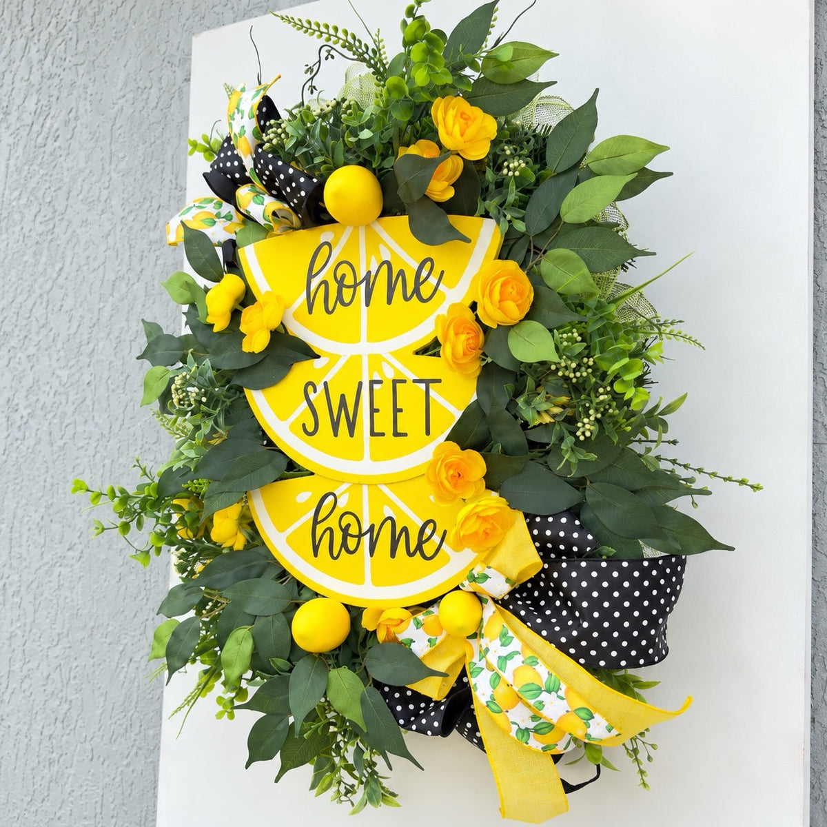 Handmade Lemon Sweet Home Summer Wreath featuring a yellow lemon-slice Home Sweet Home sign, bright yellow roses, decorative lemons, lush green foliage, and black-and-white polka-dot ribbon displayed on a white door.