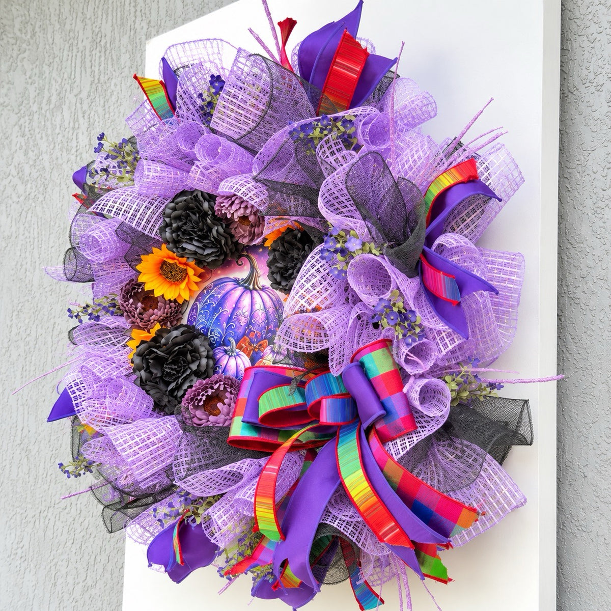 Right angle of Velvet Eclipse Halloween wreath showing pumpkin centerpiece and layered bow