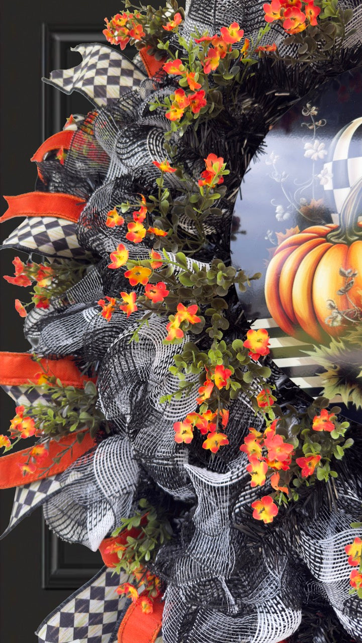 Harlequin Harvest Manor Wreath featuring lavender deco mesh, black florals, vibrant harlequin ribbon, sunflowers, and a whimsical purple pumpkin centerpiece displayed on a black front door.