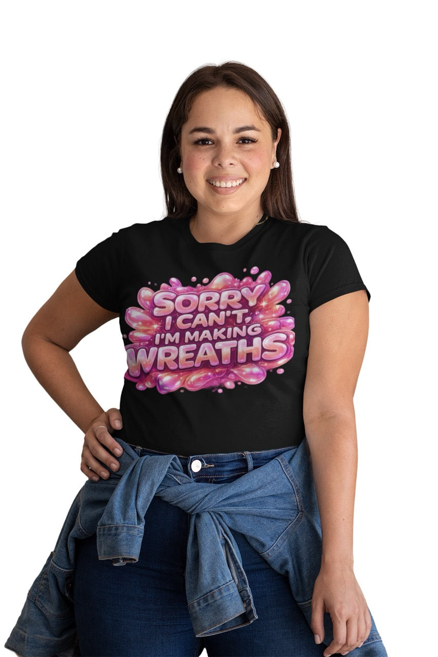 Graphic t-shirt featuring the phrase “Sorry I Can’t, I’m Making Wreaths” in bold bubble-style lettering, designed for wreath makers, crafters, and DIY enthusiasts.