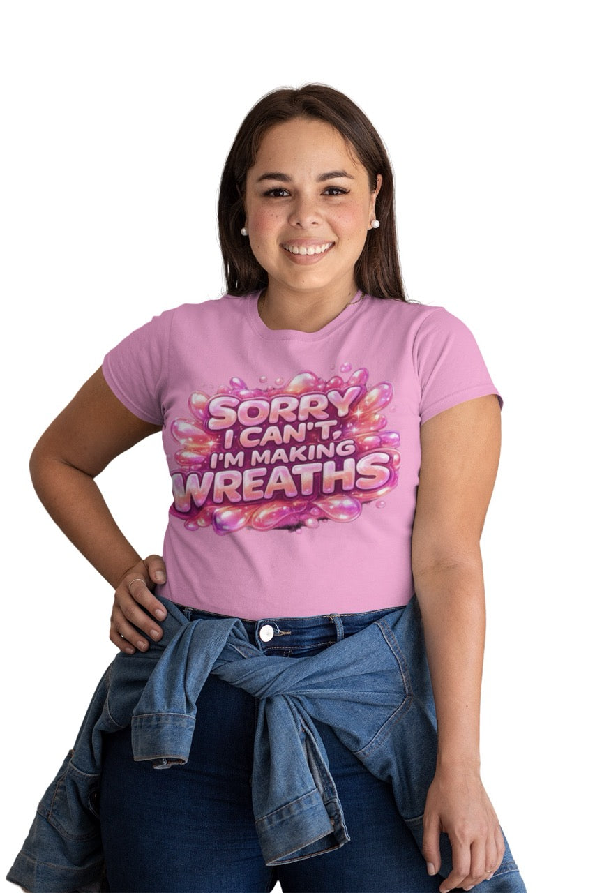 Graphic t-shirt featuring the phrase “Sorry I Can’t, I’m Making Wreaths” in bold bubble-style lettering, designed for wreath makers, crafters, and DIY enthusiasts.
