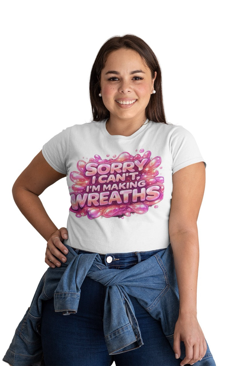 Graphic t-shirt featuring the phrase “Sorry I Can’t, I’m Making Wreaths” in bold bubble-style lettering, designed for wreath makers, crafters, and DIY enthusiasts.