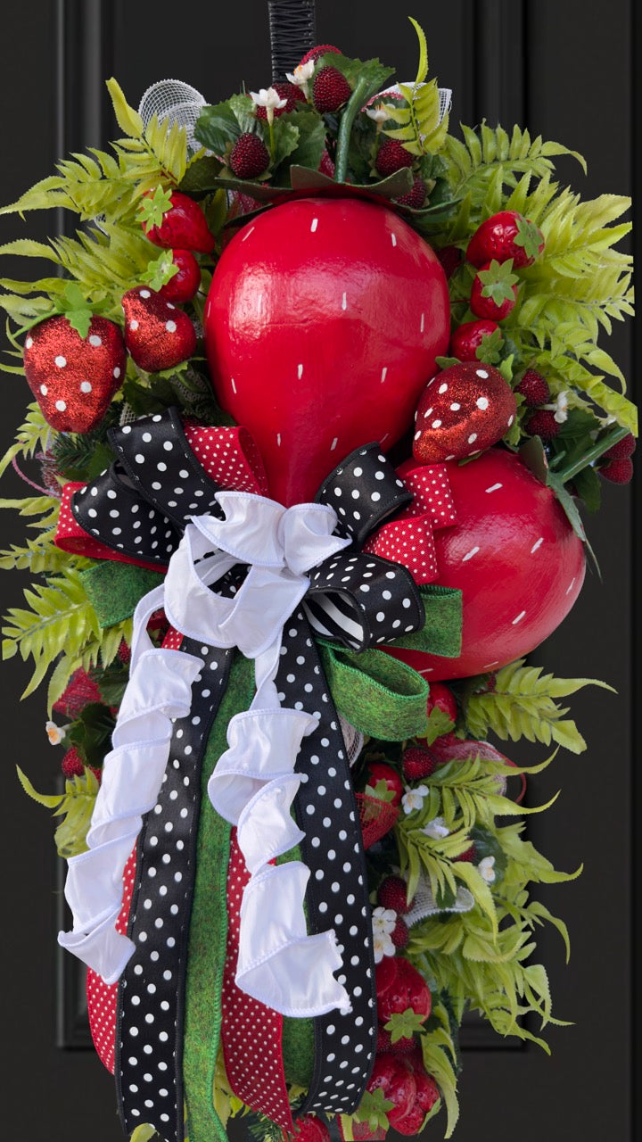 Luxury handmade strawberry door swag with oversized red strawberries, glitter strawberry ornaments, bright green foliage, white flowers, and a designer black, red, white, and green ribbon bow, perfect for summer front door décor and farmhouse-style decorating. 🍓✨