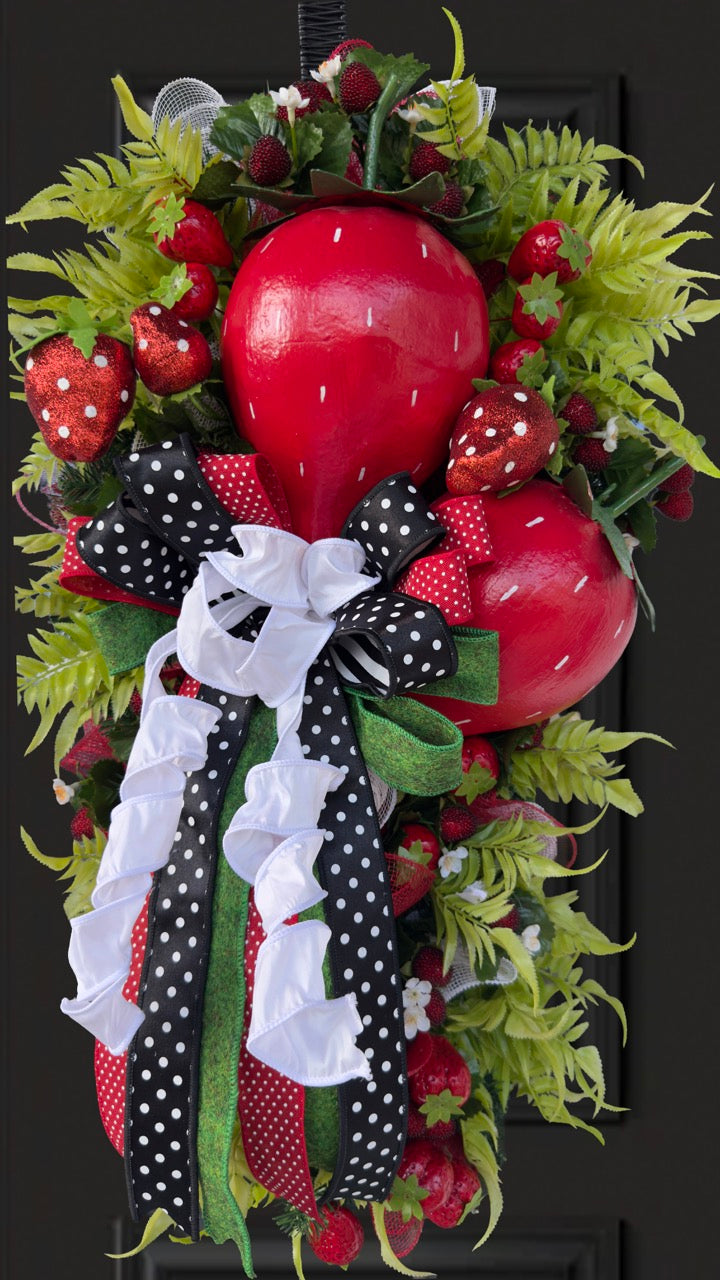 Luxury handmade strawberry door swag with oversized red strawberries, glitter strawberry ornaments, bright green foliage, white flowers, and a designer black, red, white, and green ribbon bow, perfect for summer front door décor and farmhouse-style decorating. 🍓✨