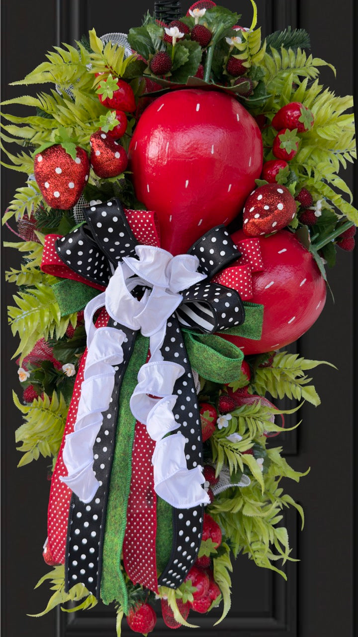Luxury handmade strawberry door swag with oversized red strawberries, glitter strawberry ornaments, bright green foliage, white flowers, and a designer black, red, white, and green ribbon bow, perfect for summer front door décor and farmhouse-style decorating. 🍓✨