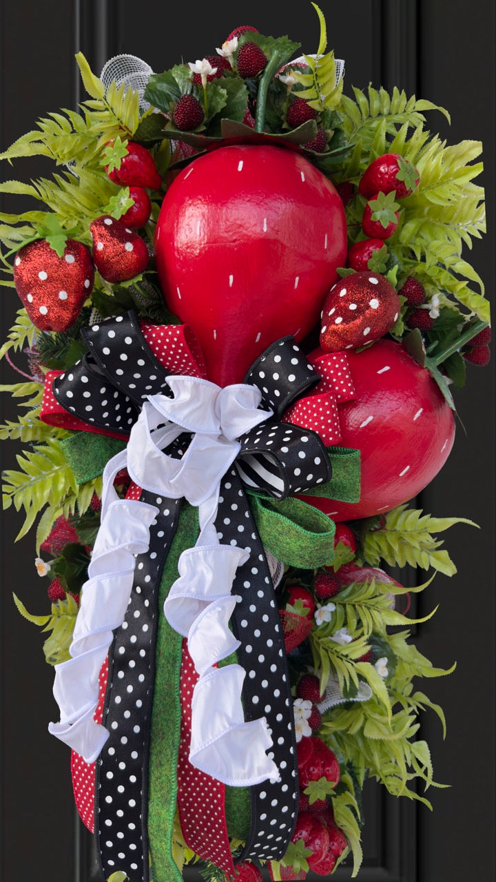 Luxury handmade strawberry door swag with oversized red strawberries, glitter strawberry ornaments, bright green foliage, white flowers, and a designer black, red, white, and green ribbon bow, perfect for summer front door décor and farmhouse-style decorating. 🍓✨