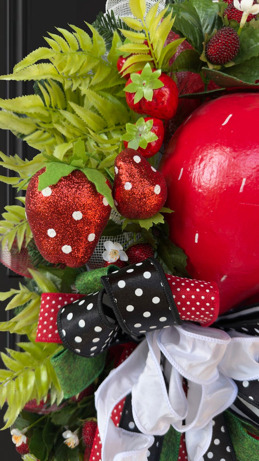 Luxury handmade strawberry door swag with oversized red strawberries, glitter strawberry ornaments, bright green foliage, white flowers, and a designer black, red, white, and green ribbon bow, perfect for summer front door décor and farmhouse-style decorating. 🍓✨