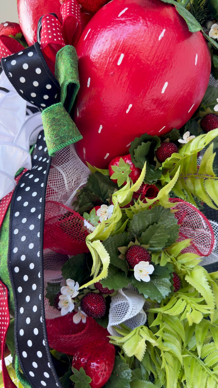 Luxury handmade strawberry door swag with oversized red strawberries, glitter strawberry ornaments, bright green foliage, white flowers, and a designer black, red, white, and green ribbon bow, perfect for summer front door décor and farmhouse-style decorating. 🍓✨