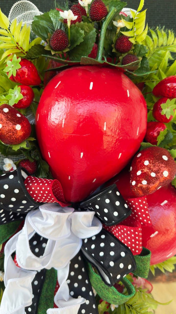 Luxury handmade strawberry door swag with oversized red strawberries, glitter strawberry ornaments, bright green foliage, white flowers, and a designer black, red, white, and green ribbon bow, perfect for summer front door décor and farmhouse-style decorating. 🍓✨