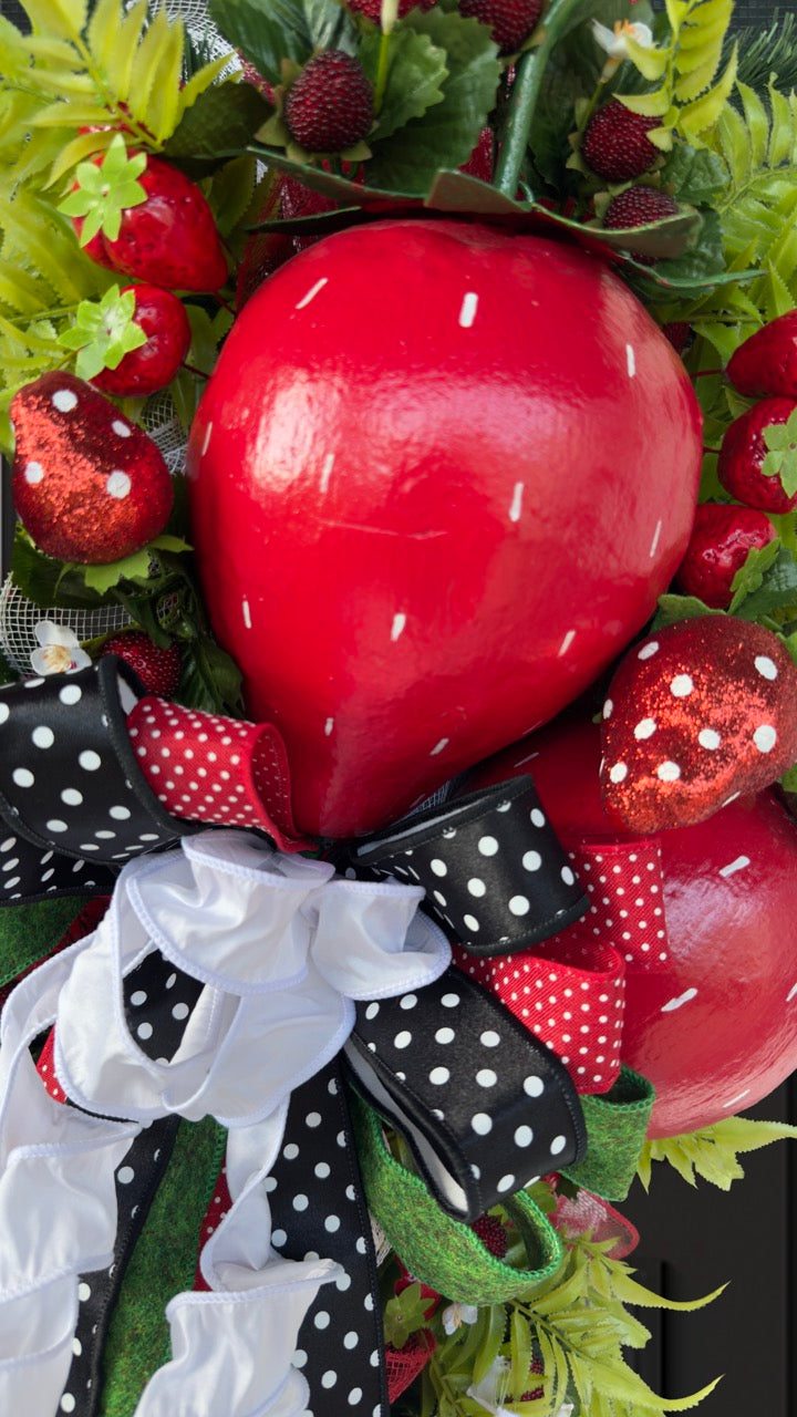 Luxury handmade strawberry door swag with oversized red strawberries, glitter strawberry ornaments, bright green foliage, white flowers, and a designer black, red, white, and green ribbon bow, perfect for summer front door décor and farmhouse-style decorating. 🍓✨