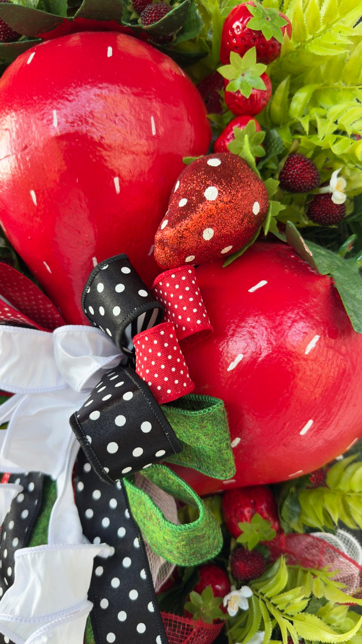 Luxury handmade strawberry door swag with oversized red strawberries, glitter strawberry ornaments, bright green foliage, white flowers, and a designer black, red, white, and green ribbon bow, perfect for summer front door décor and farmhouse-style decorating. 🍓✨