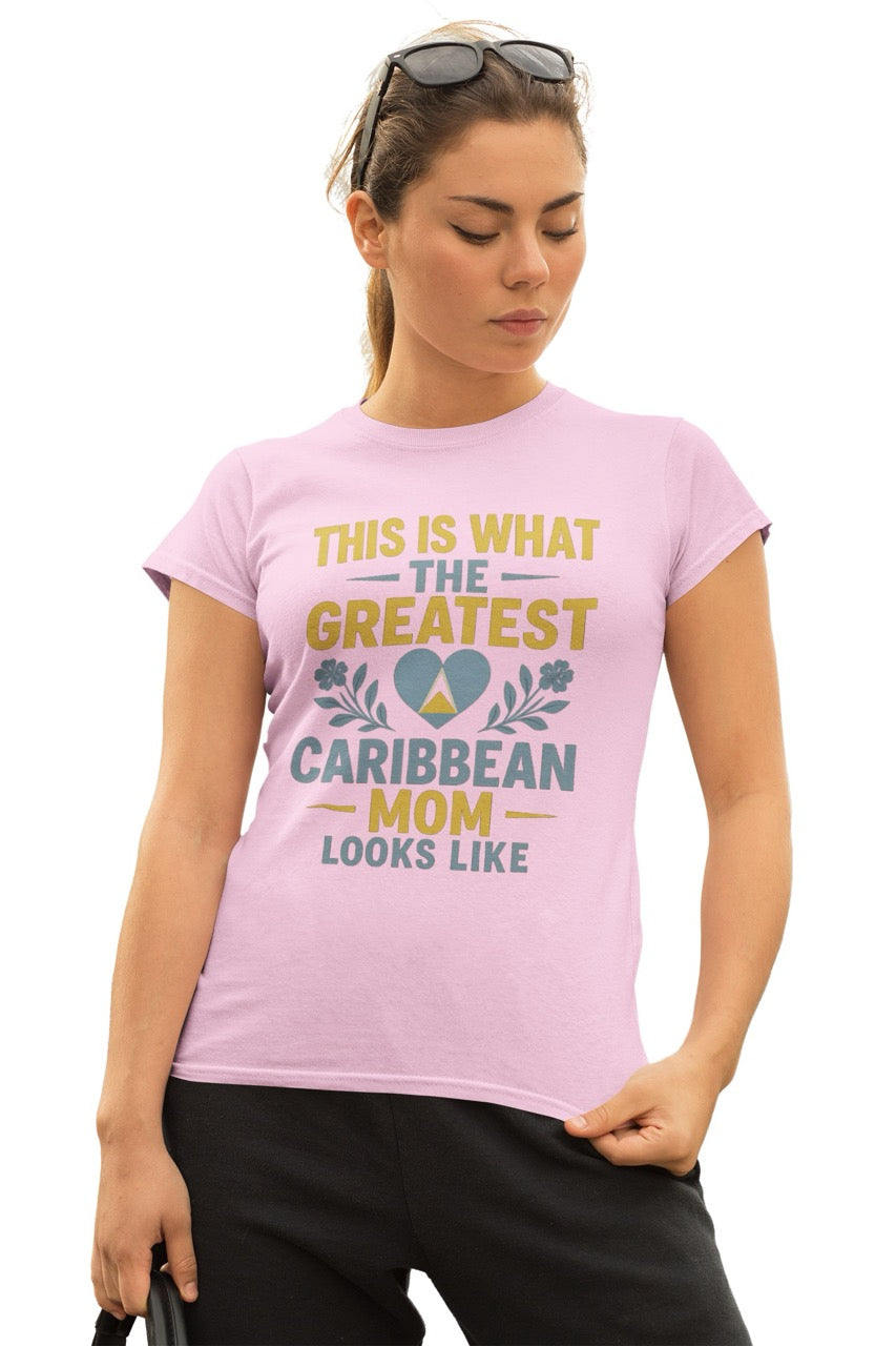 Woman wearing a pink T-shirt with text reading “This is what the greatest Caribbean mom looks like,” featuring a heart with island-inspired colors and floral accents.