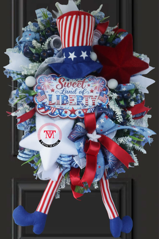 Sweet Land of Liberty patriotic swag wreath with Uncle Sam legs, red white blue ribbons, and star accents