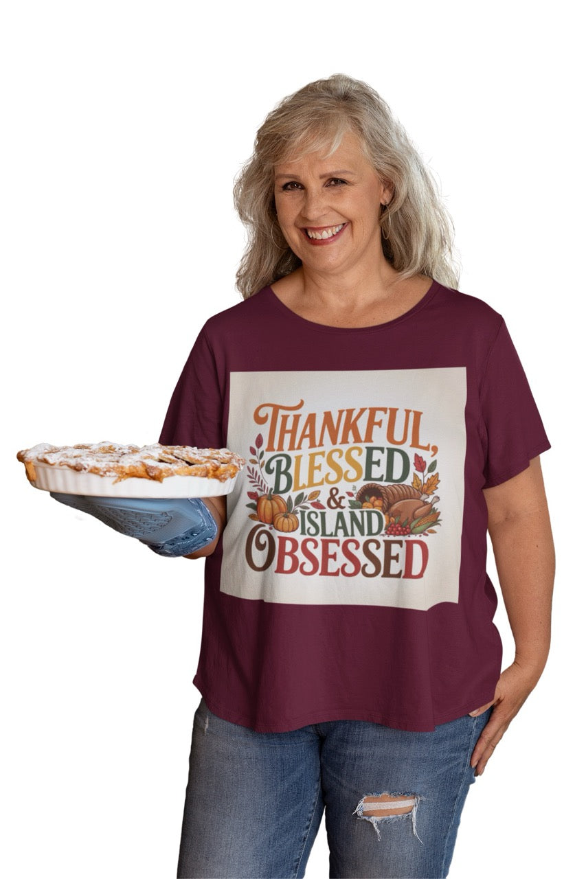 A cheerful Caribbean-inspired Thanksgiving design featuring the phrase “Thankful, Blessed & Island Obsessed.” The text is styled in bold autumn colors — orange, gold, green, and deep red — surrounded by pumpkins, colorful fall leaves, and a cornucopia overflowing with fruits and vegetables. The design beautifully blends traditional Thanksgiving symbols with tropical warmth, celebrating gratitude and island pride.