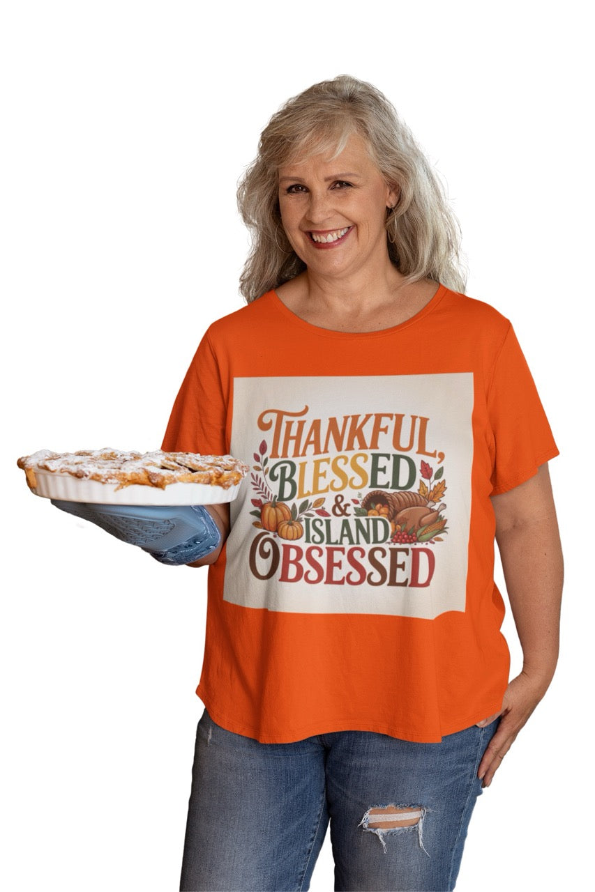 A cheerful Caribbean-inspired Thanksgiving design featuring the phrase “Thankful, Blessed & Island Obsessed.” The text is styled in bold autumn colors — orange, gold, green, and deep red — surrounded by pumpkins, colorful fall leaves, and a cornucopia overflowing with fruits and vegetables. The design beautifully blends traditional Thanksgiving symbols with tropical warmth, celebrating gratitude and island pride.