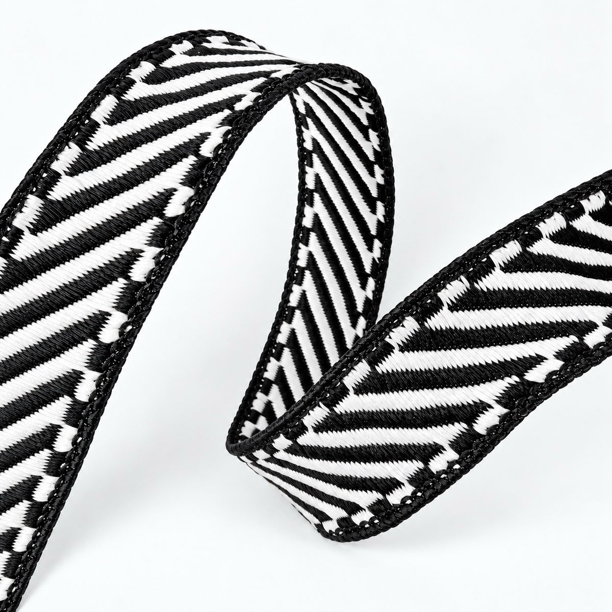 Farrisilk Shapeshifter black and white geometric wired ribbon, 1 inches wide, displayed on a full 10-yard spool with decorative ribbon loops.
